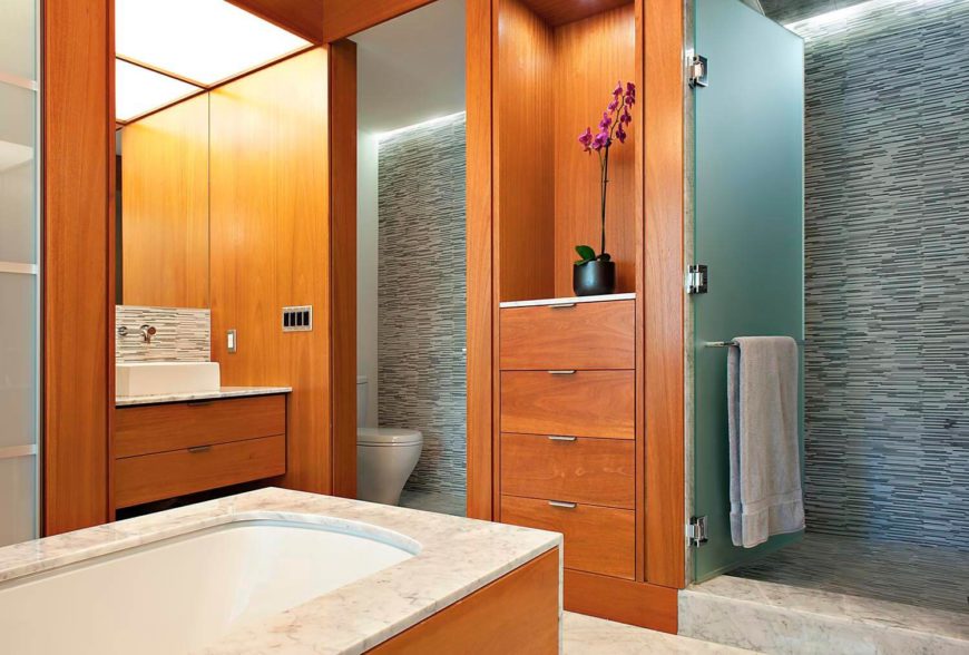 浴室采用大面积的大理石和轻质天然硬木，设有中央“岛式”浴室和步入式玻璃门淋浴。左边是柜台上方的水池。