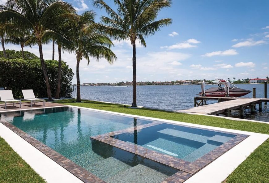 当你有一个靠近湖泊的游泳池时，棕榈树是放置在这两个水体之间的完美特征。