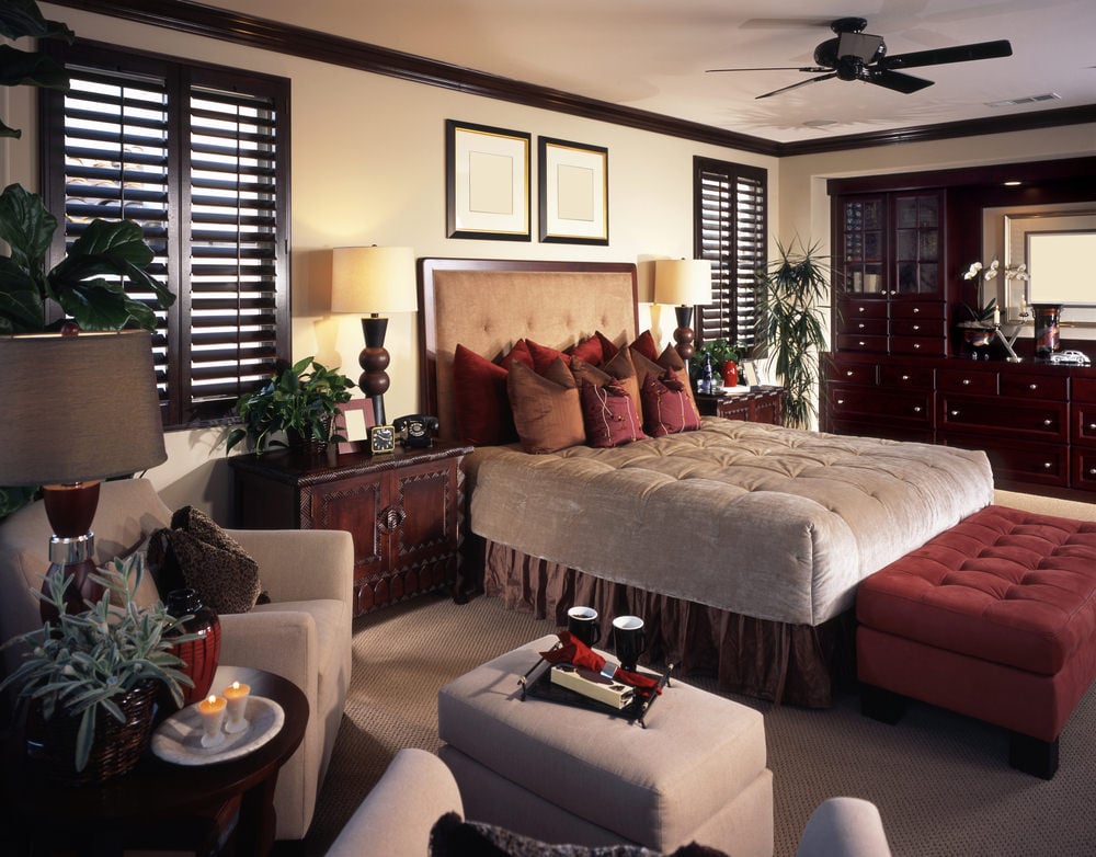 一间主卧室，配有豪华的床和附近的休息区，设置在地毯地板上。