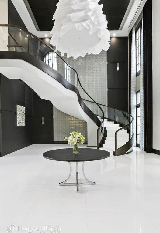 这个当代住宅设有一个非常时尚的门厅，结合了黑色和白色。楼梯和顶灯都非常漂亮。