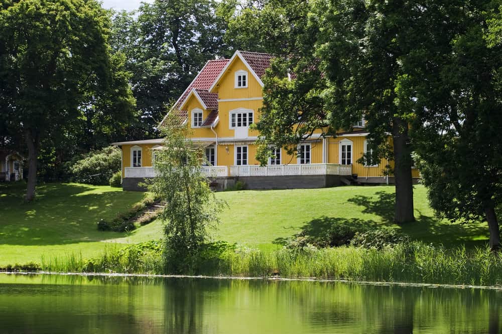 巨大的财产的惊人的大黄湖房子与倾斜的草坪到成熟树围拢的湖。家里有白色修剪和红色瓦片屋顶。绝对惊艳。