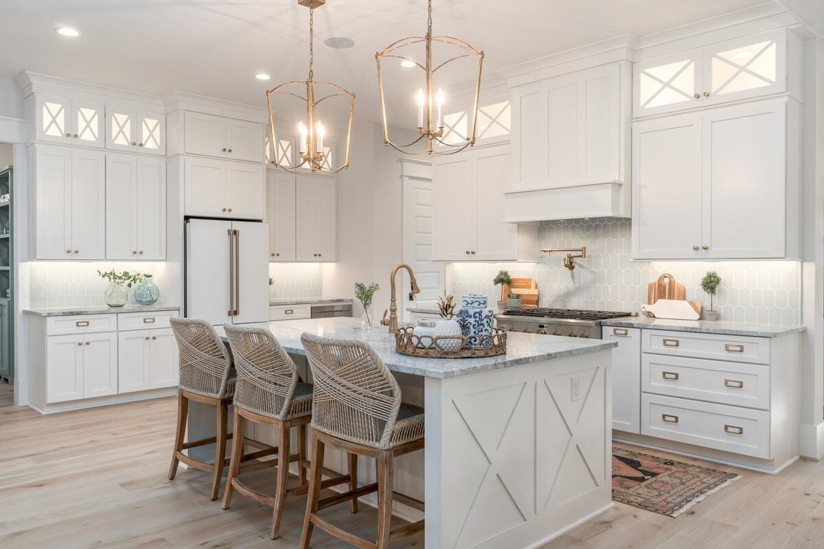 轻木元素与白色的厨房设计相结合，给人以清新舒适的感觉。硬件和照明的黄铜口音为该地区增添了优雅。