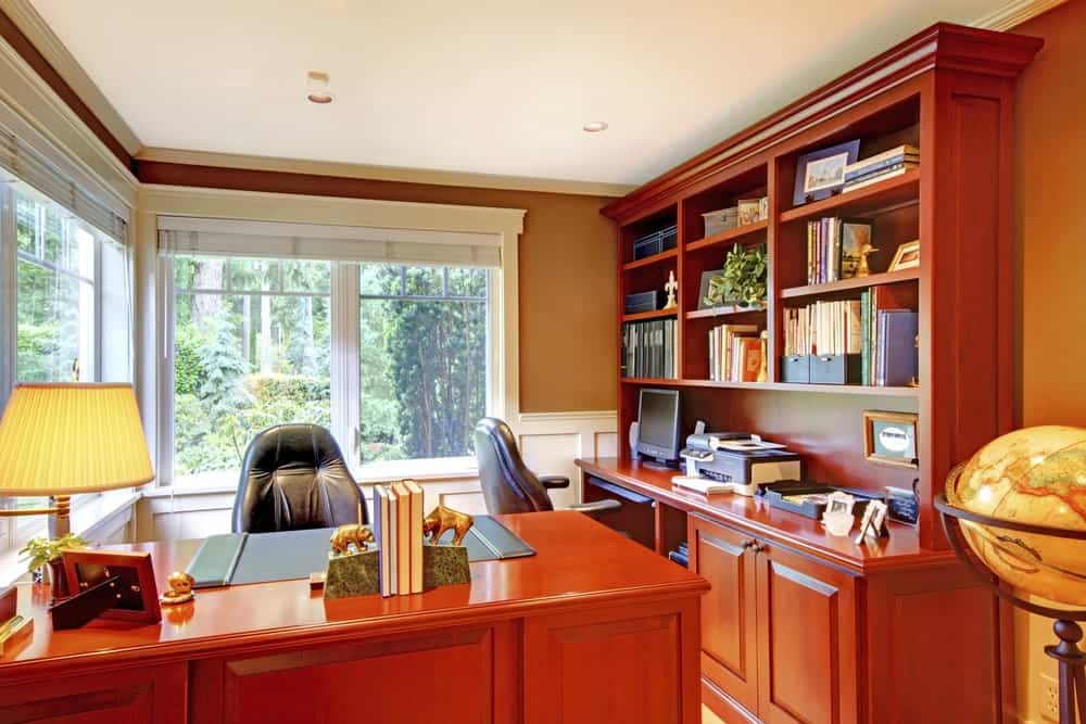 有木制家具和大窗户的家庭办公室。
