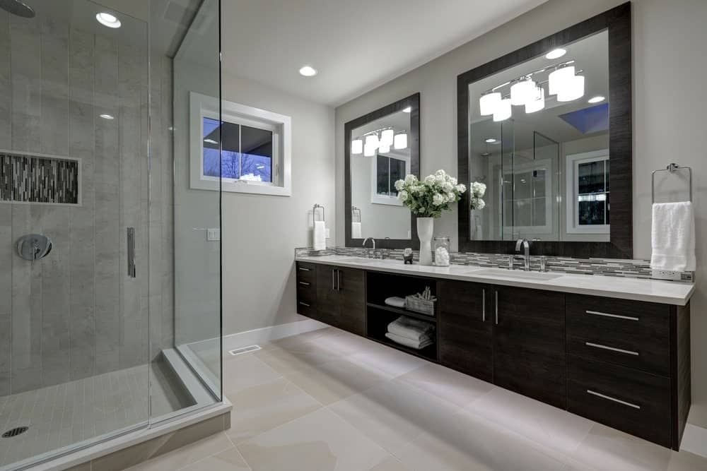 现代主浴室，带玻璃淋浴，浮动梳妆台和双水槽。