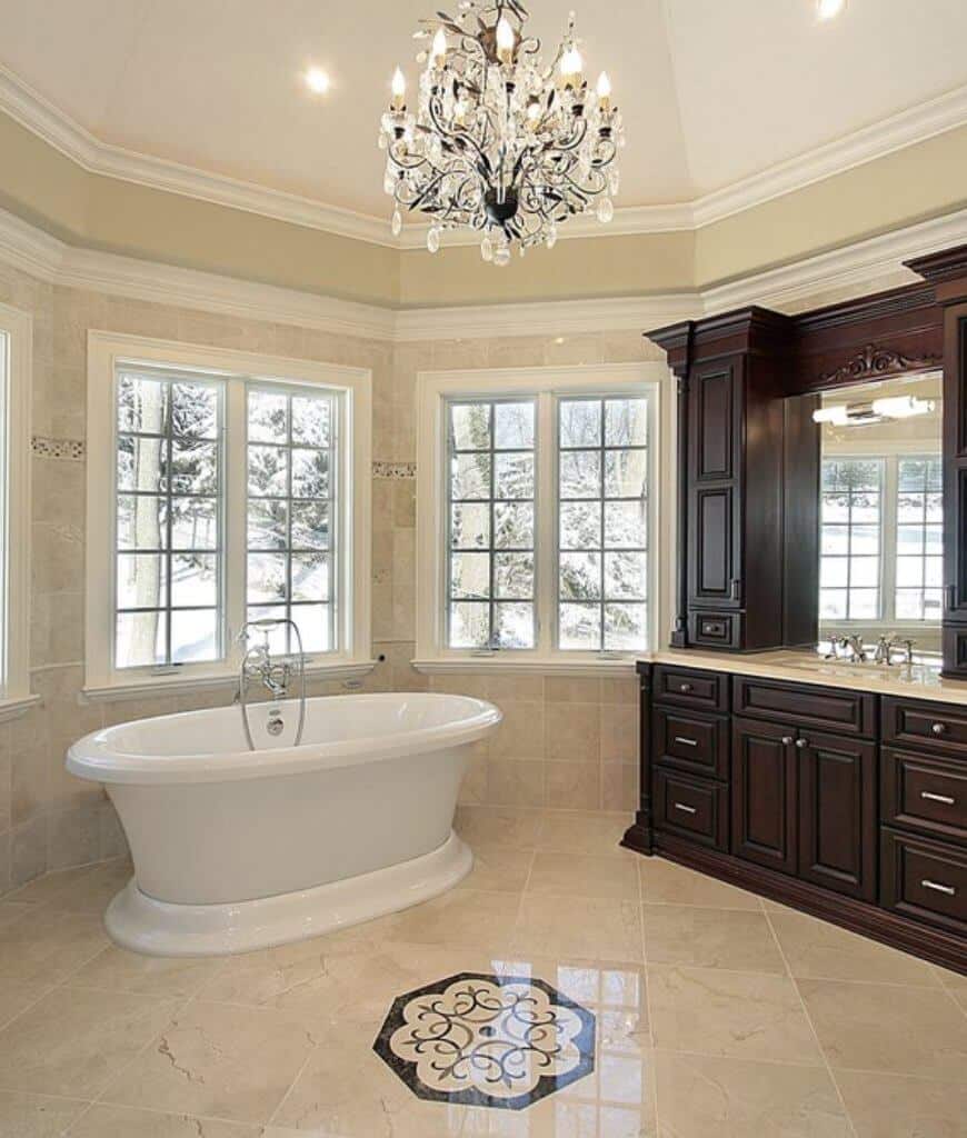 一个独立的浴缸和木制洗手台充满了主浴室，并由一个华丽的枝形吊灯和安装在穹顶天花板上的嵌入式灯照亮。