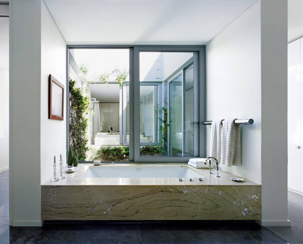 专注地看这个主浴室的滑动玻璃窗旁的定制浸入式浴缸。