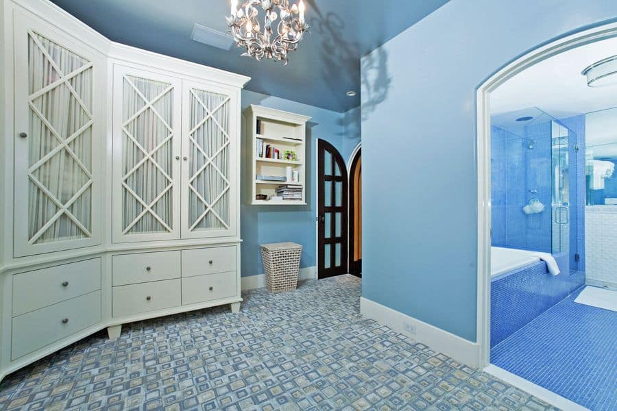主浴室有一个壁橱区域，由华丽的枝形吊灯照明。浴室有蓝色瓷砖地板和墙壁。它也有一个插入式浴缸和一个步入式淋浴间。