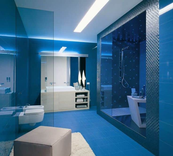 定制的主浴室，蓝色瓷砖地板和蓝色墙壁，以及惊人的照明。房间提供了一个现代化的水槽柜台，有一个大水槽和一个时尚的步入式淋浴间。