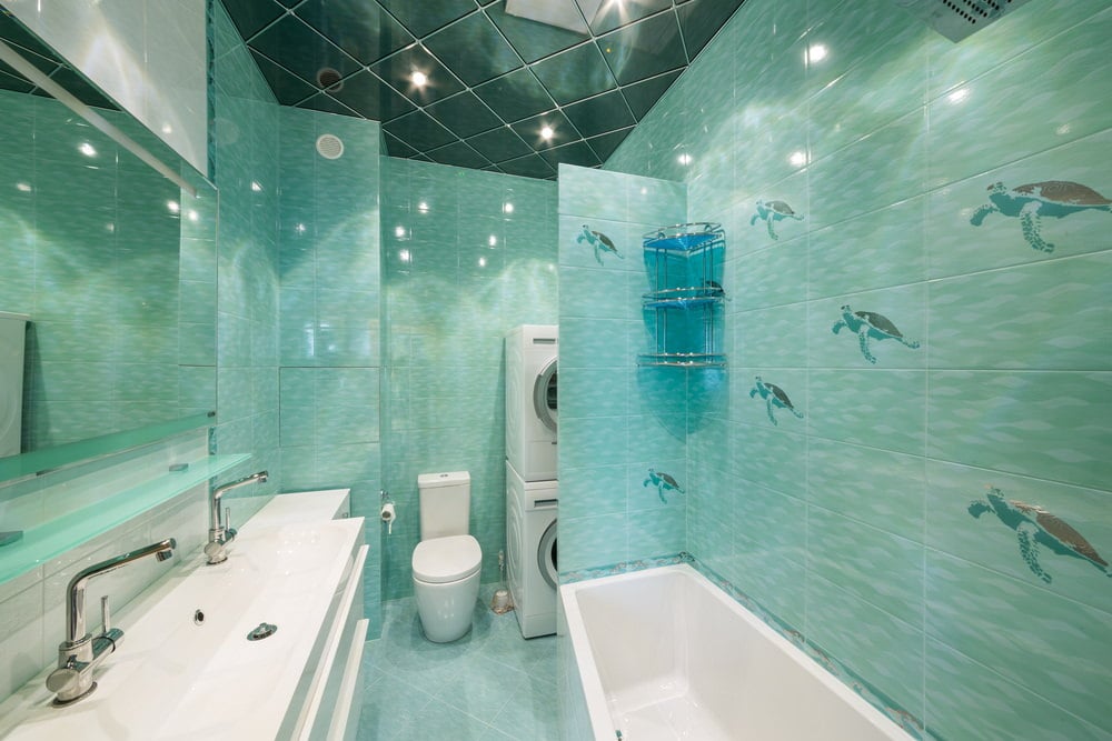 小主浴室拥有装饰绿色墙壁和优雅的绿色天花板和瓷砖地板。有一个大的双水槽柜台和一个独立的浸泡浴缸在旁边。
