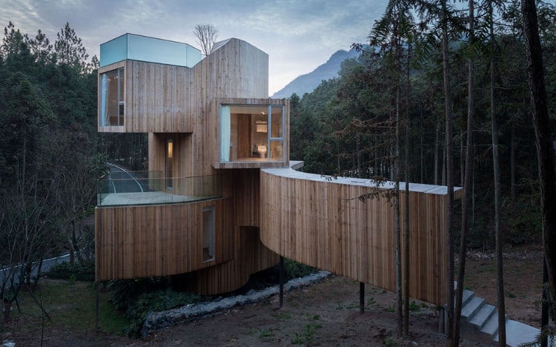 这座当代住宅拥有令人惊叹的外观设计，周围是安静和平的树林。