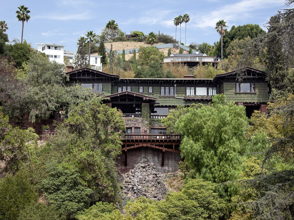 这是房子后面俯瞰好莱坞山悬崖的鸟瞰图。你可以在这里看到房子外墙的深色色调与周围的高大树木相辅相成。图片来自Toptenrealestatedeals.com。