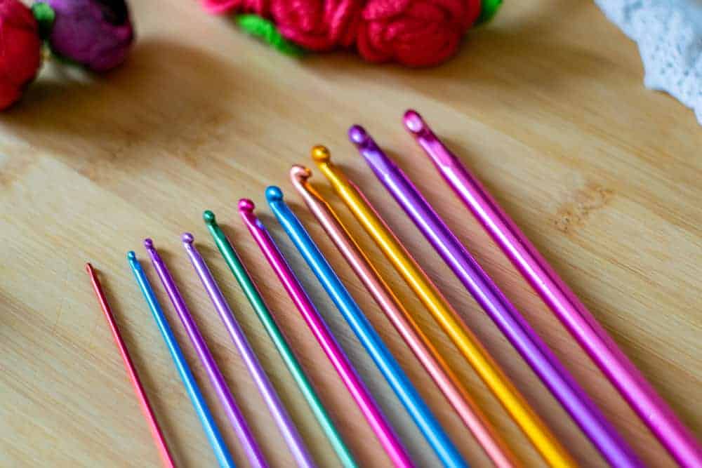 在一张木书桌上的多彩多姿的突尼斯钩针编织勾子。