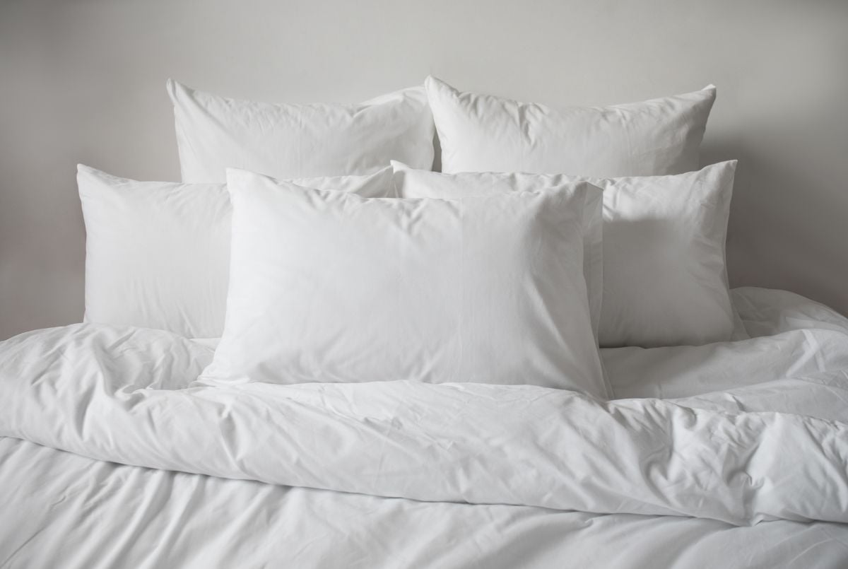 白色的枕头和白色的毯子放在白色的墙上