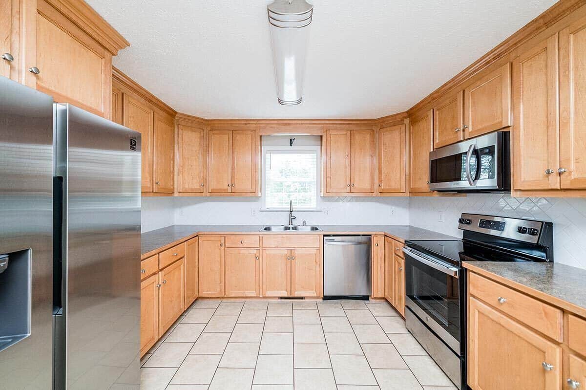 厨房配有不锈钢用具，双水槽，木制橱柜和花岗岩台面。