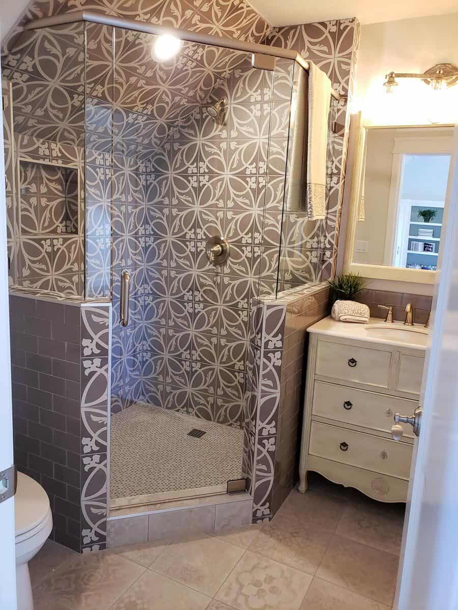 灰色图案瓷砖突出了浴室的步入式淋浴。