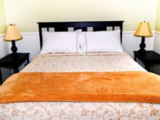 特大号床，橙色毯子。