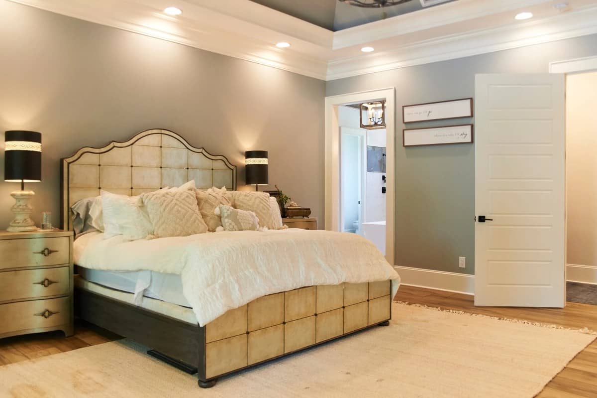 主卧室设有托盘天花板和一张可爱的木床，两侧配有配套的床头柜。