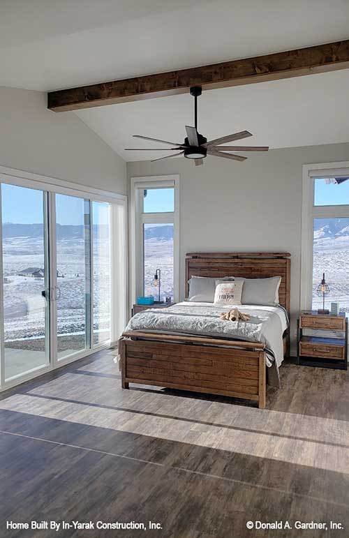 这间卧室有木制家具，与硬木地板和裸露的木梁相匹配。